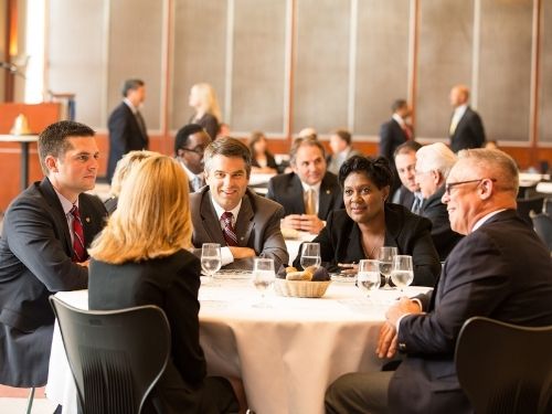 Group of people at a luncheon dressed in black business formal attire