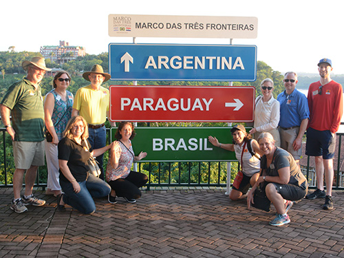 Rotary Friendship Exchange group near signs to Argentina, Brasil, and Paraguay
